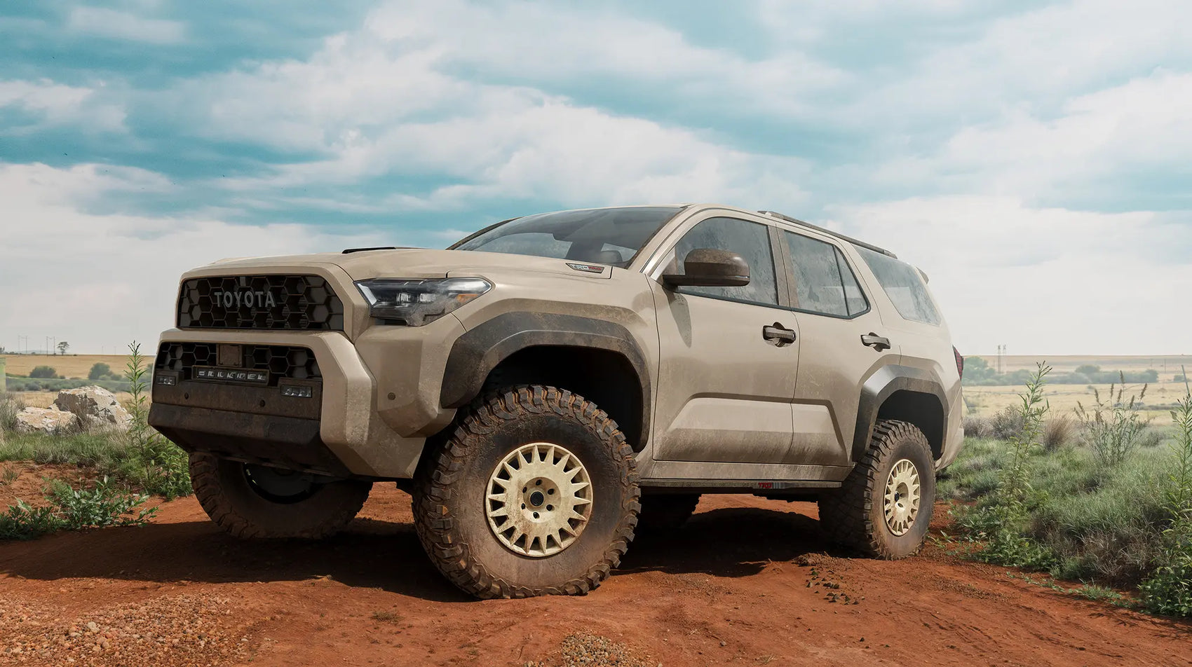 Blackhorn Offroad GR17 FDE with BFGoodrich KM3 on Toyota 6th Gen 4Runner in an Empty Sand Road Surrounded by Fields under a Cloudy Sky