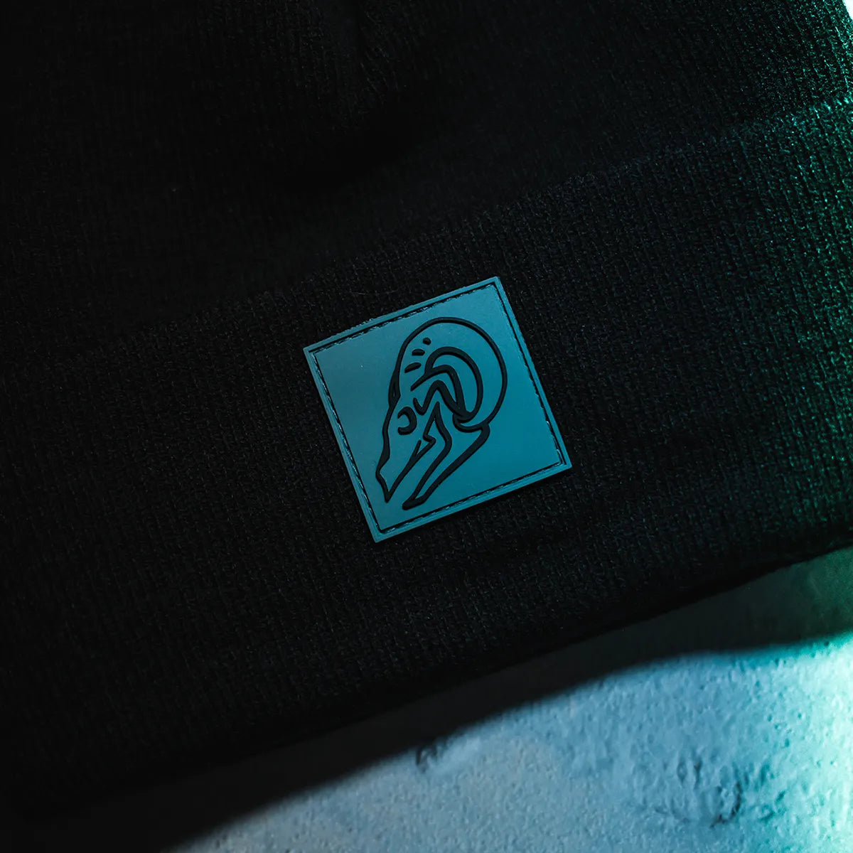 Close-up of Blackhorn Offroad "Polymark" Skull logo rubber tag on black knit beanie cuff
