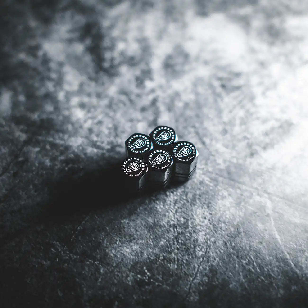 Black Blackhorn valve stem caps arranged on dark textured surface with crest logo visible.