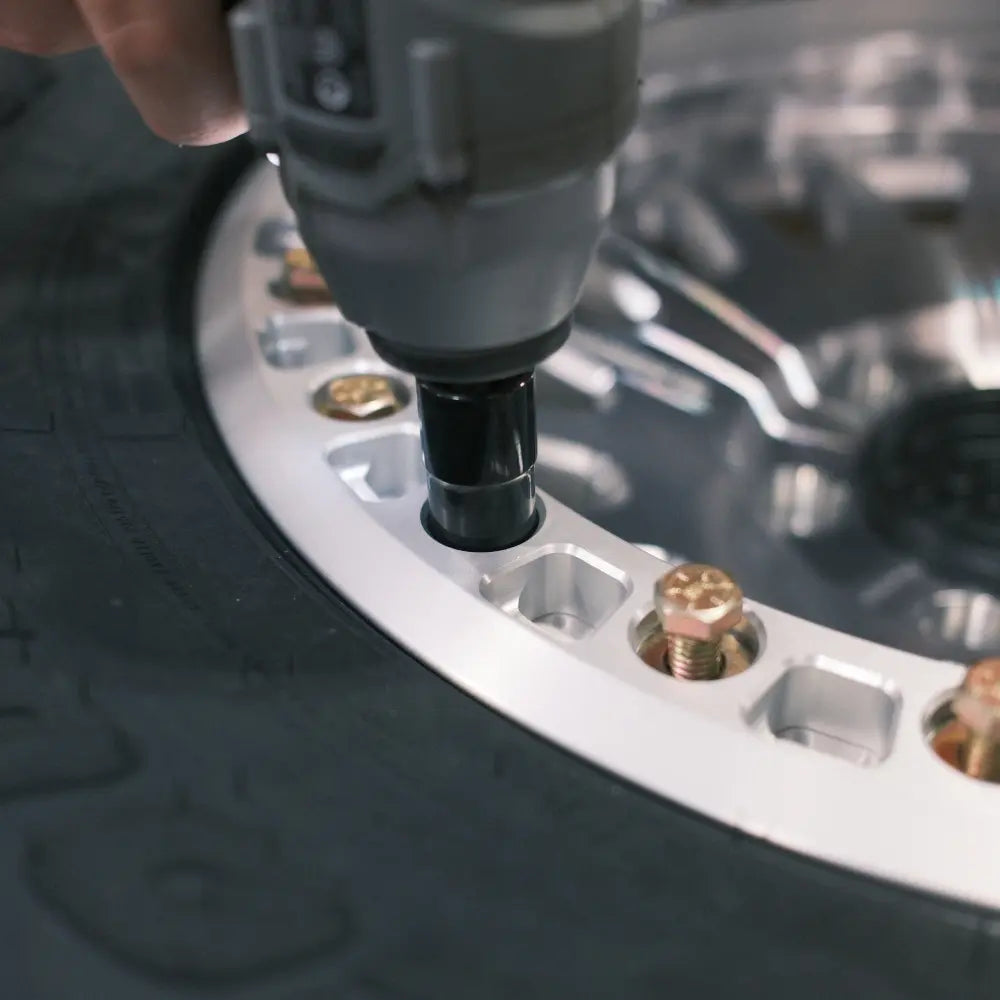 Close-up of beadlock hardware kit being tightened to secure ring onto MBF wheel, showing precise clamping and seated hardware
