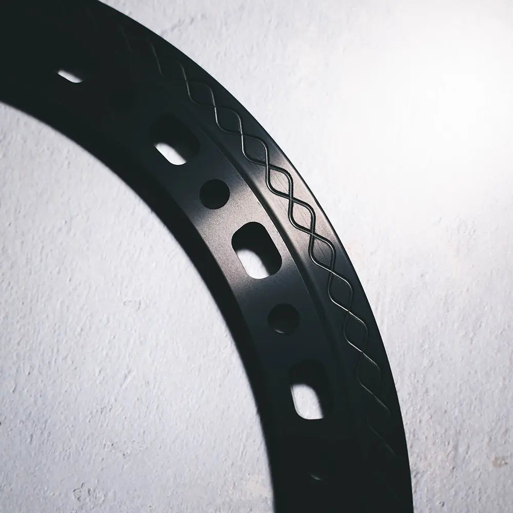 Close-up of Type 02 beadlock ring in black anodized finish with cut-outs and knurled fishtail clamp surface