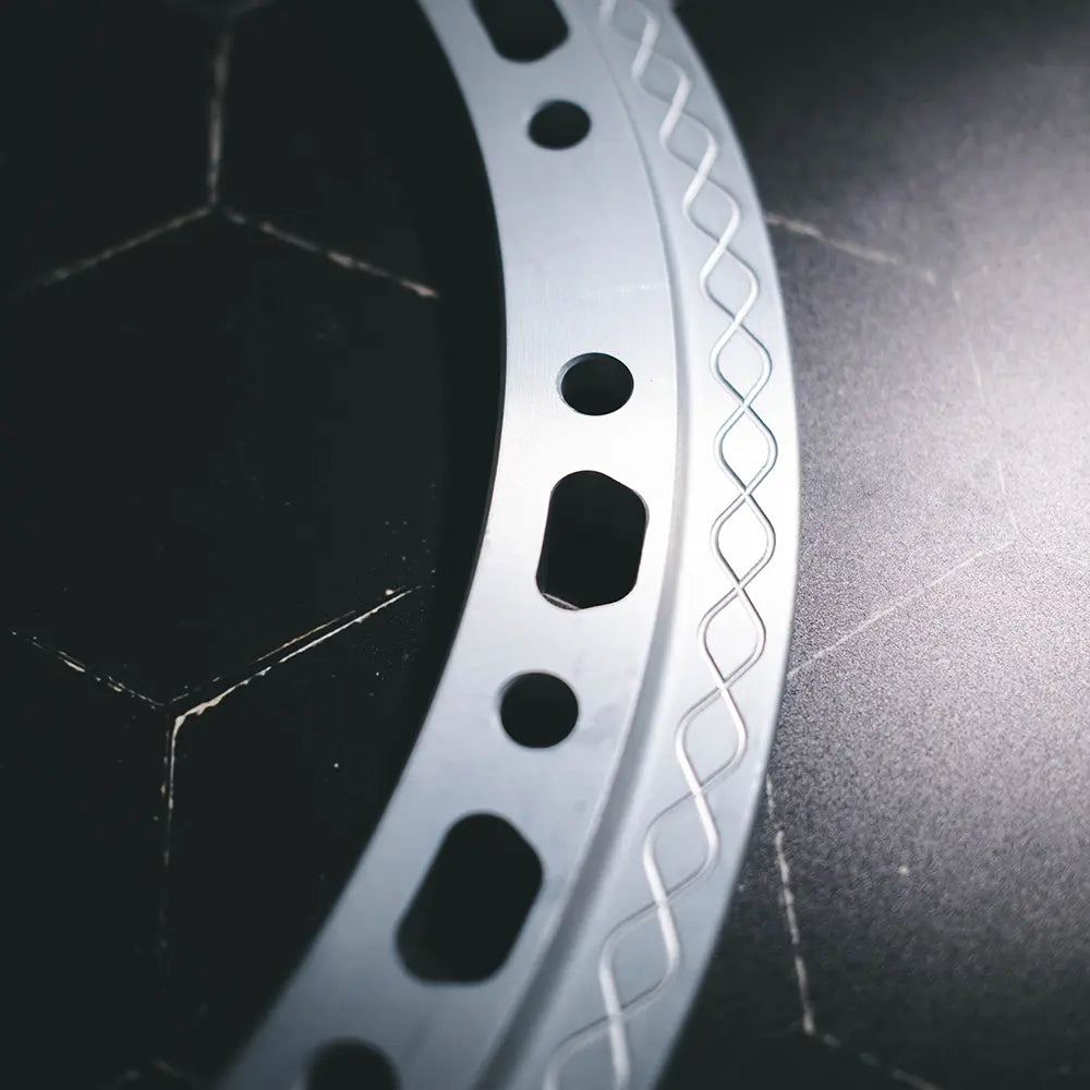 Close-up of Type 03 beadlock ring in anodized finish showing trapezoid relief and knurled fishtail clamp surface detail