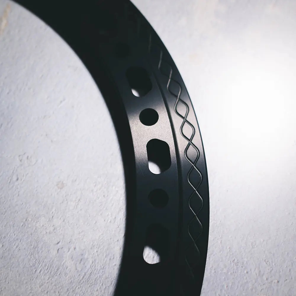 Close-up of Type 03 beadlock ring in black anodized finish highlighting sculpted edge and knurled fishtail clamp surface